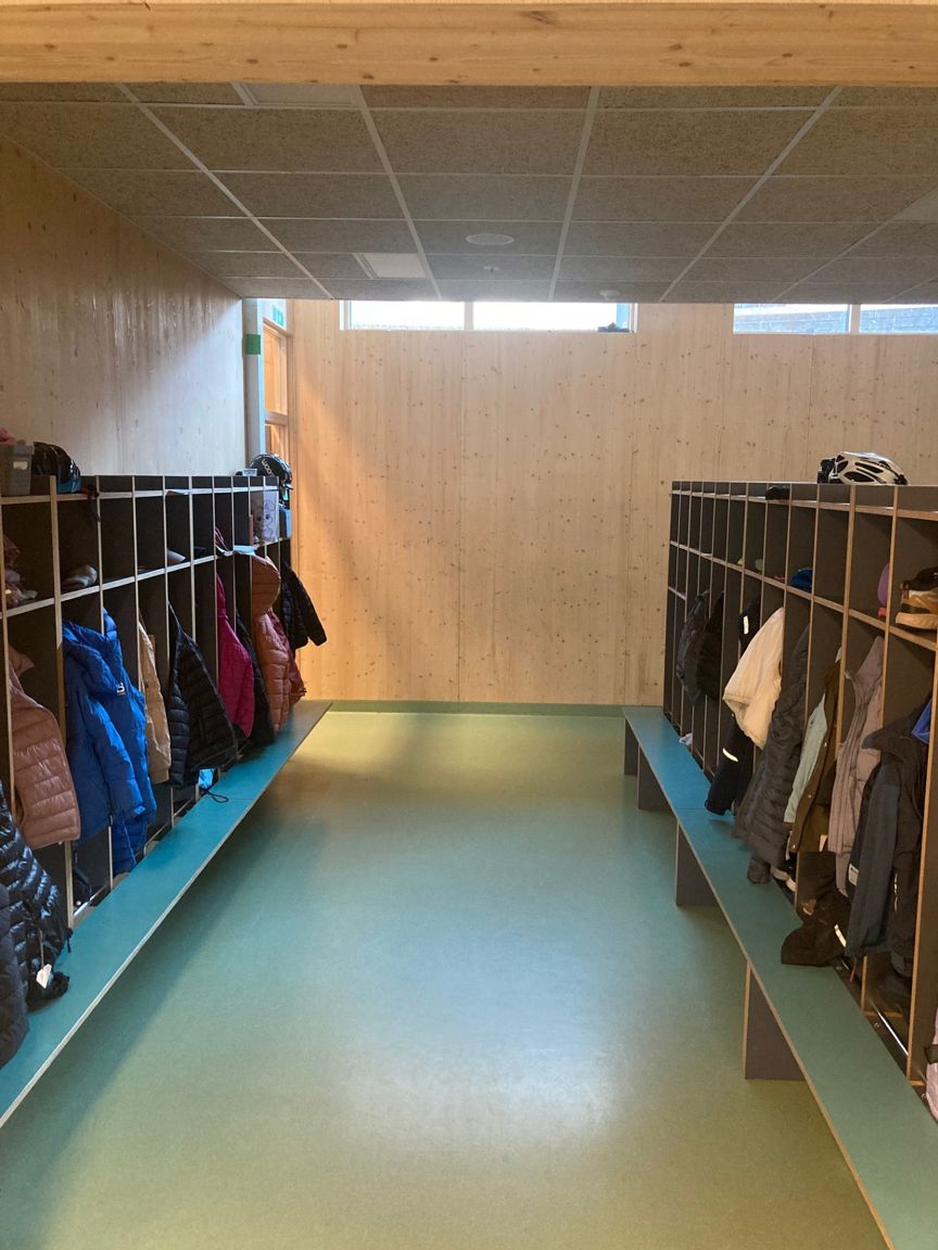 et langt blått biljardbord i et rom med en vegg full av klær